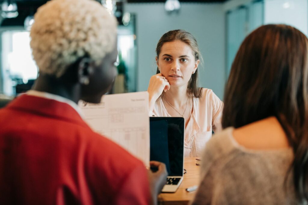 diverse coworkers discussing project in workspace 