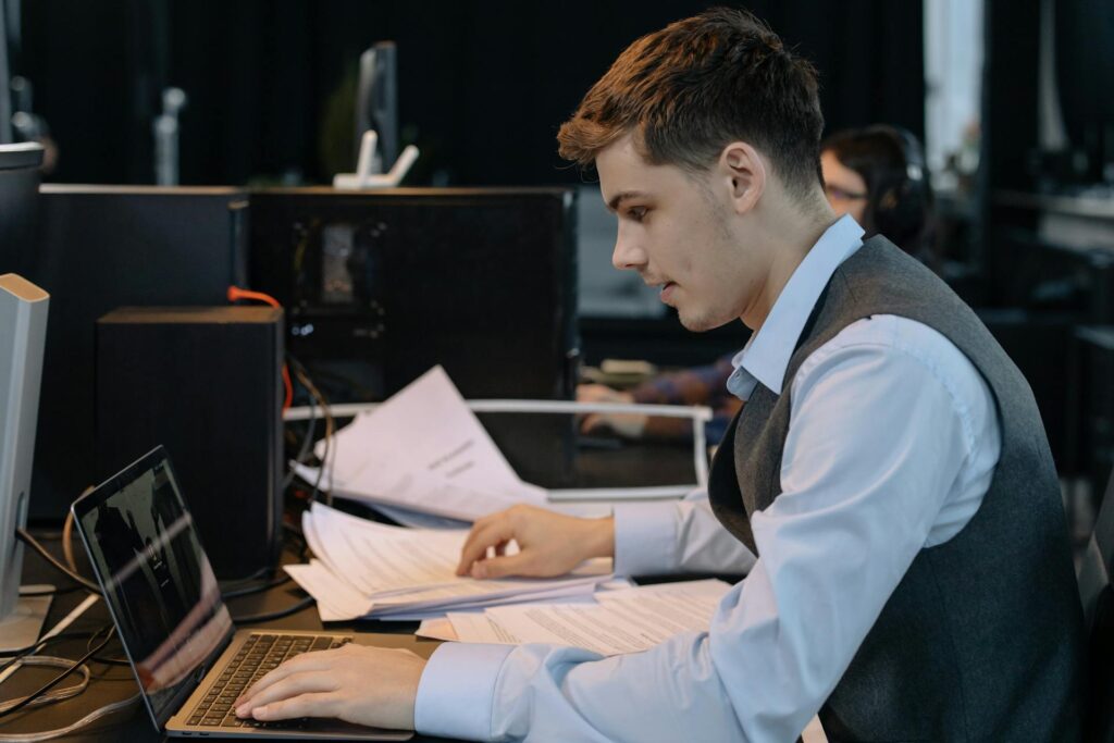  a side view of a man using laptop
